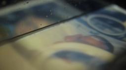 A photograph a baby in hospital is projected into a glass basin of milk.