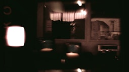 A blurry image of inside an office style room, with bright lights and reflections in the windows.