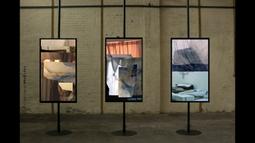 Three tv monitors are mounted portrait on metal beams with video collages playing.