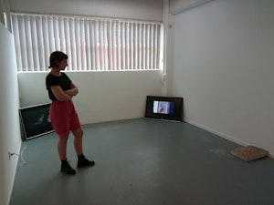 Priscilla Howe is standing in a gallery contemplating the installation of the artworks