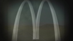 The McDonalds arches are overlaid on an image of a rural desert road and landscape.