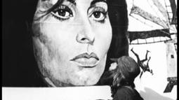 The artist kisses a billboard of Sophia Loren.