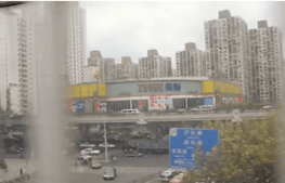 A pixelated image of a cluster of high rise shanghai apartments taken from a train