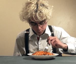 Theo is dressed as David Bowie with bleached hair, button up shirt with suspenders, eats canned spaghetti