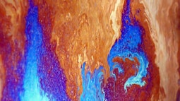 A neon blue and orange colours cape of liquid seen extremely close up