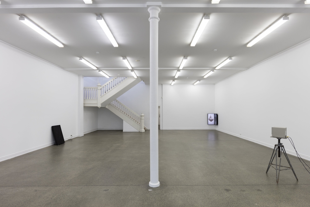 A sparse gallery with three installations in opposite corners