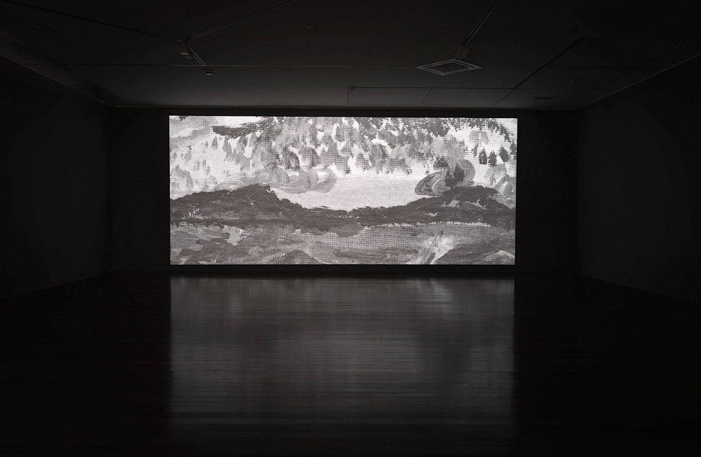 An image of a painted landscape projected in a gallery