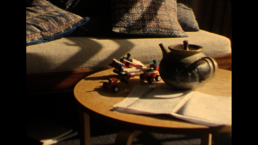 An idyllic image of a coffee table containing a tea pot, some pages of poems and childrens lego