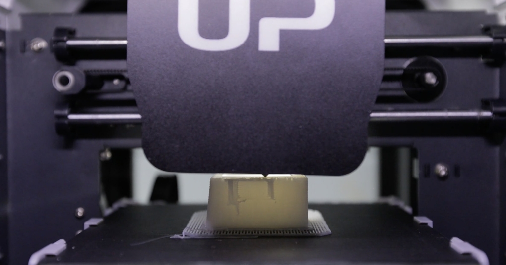 A close up of a 3D printer, constructing an unidentified object