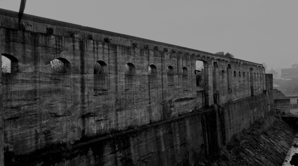 A dilapidated concrete structure photographed in black and white.