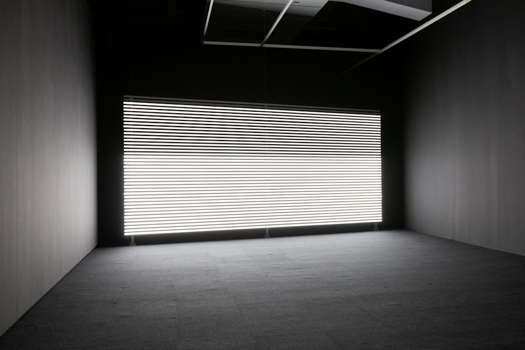 a wall covered in horizontal bands of white light