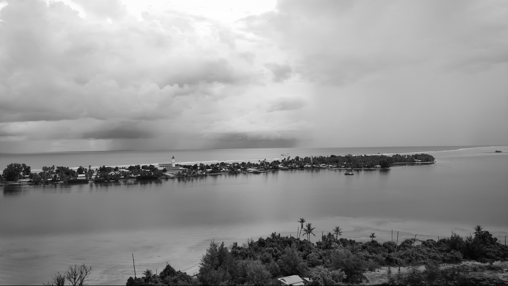 Black and white footage of a Pacific atoll surrounded by ocean