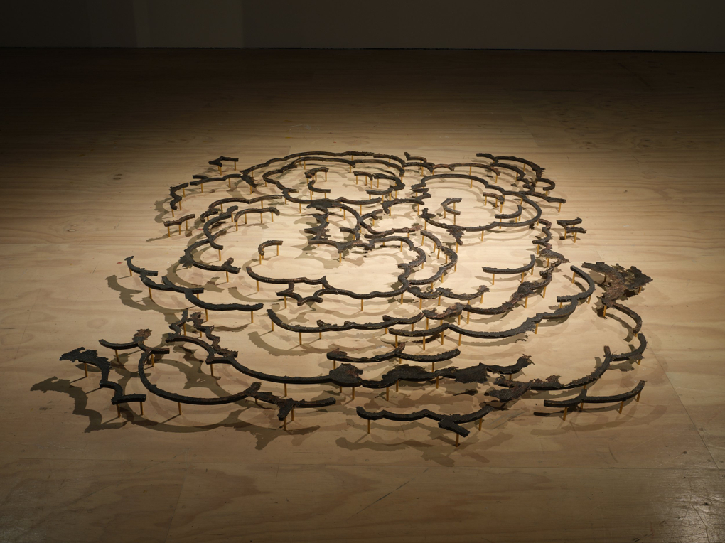 A series of metal sculptures placed in proximity suggest the edges of billowing clouds.