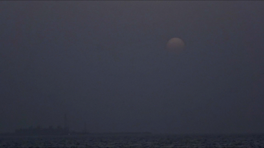 The horizon line of a blue-black sea