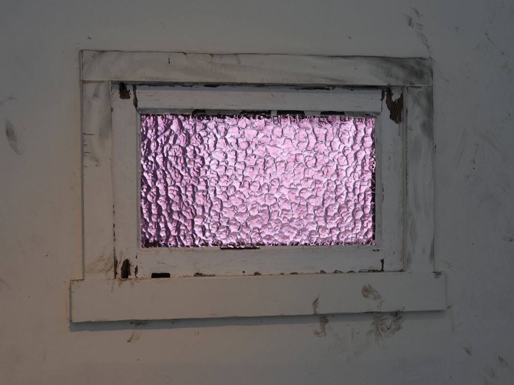 A purple textured glass window with white window frames