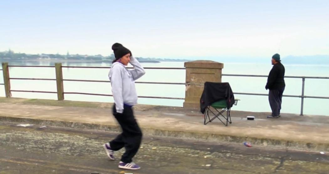 Rebecca is shown mid-move, dancing over a bridge