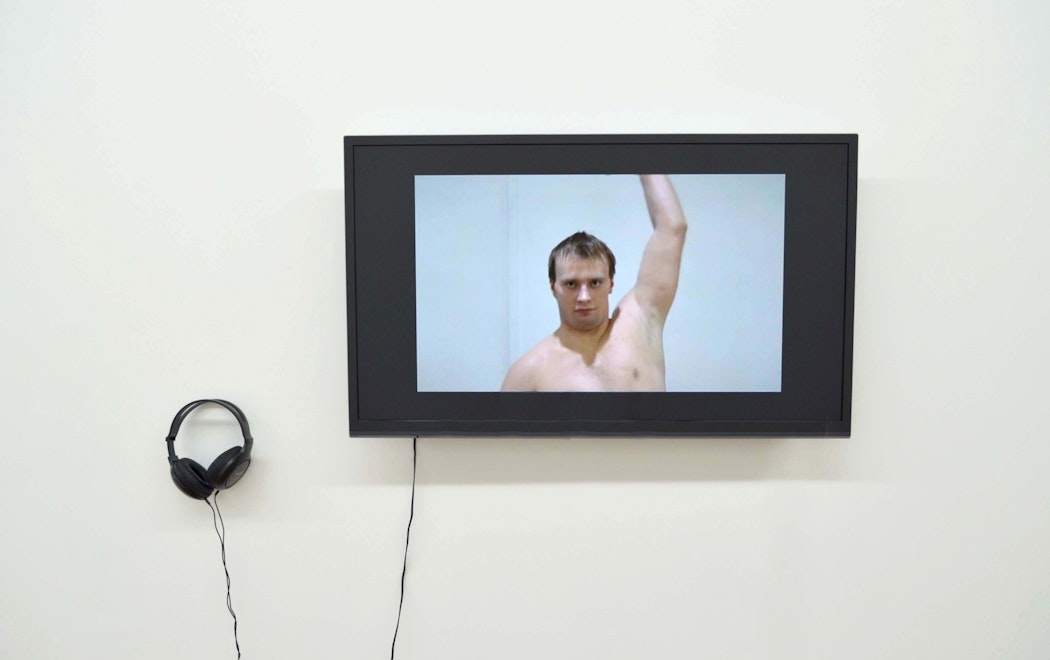 A tv with headphones shows a man lifting his arm up