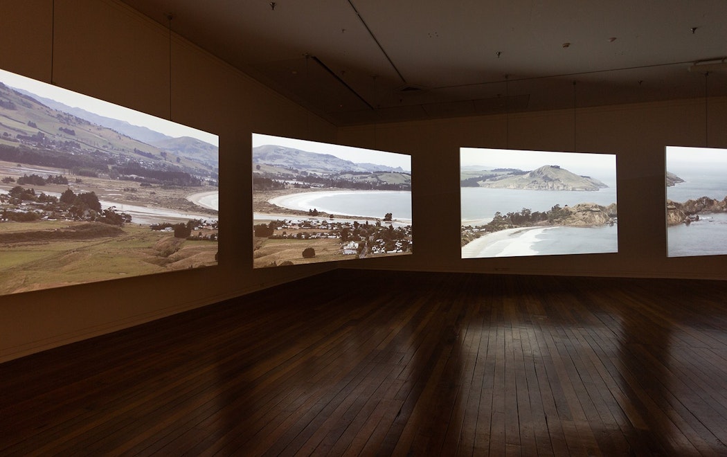 A four channel video installation in a darkened gallery showing a landscape