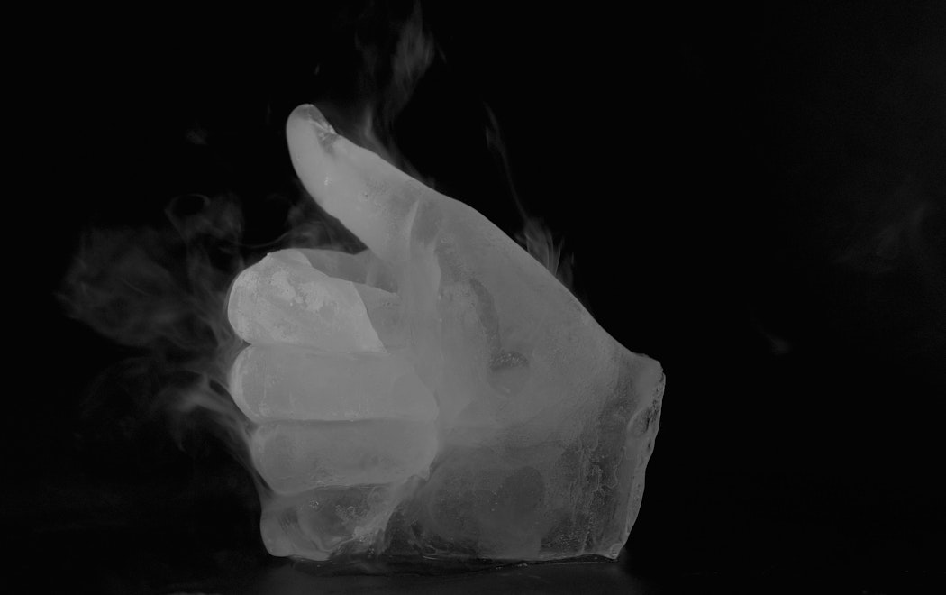 A hand made of ice gives the thumbs up. Vaporous icy mist arises from the hand