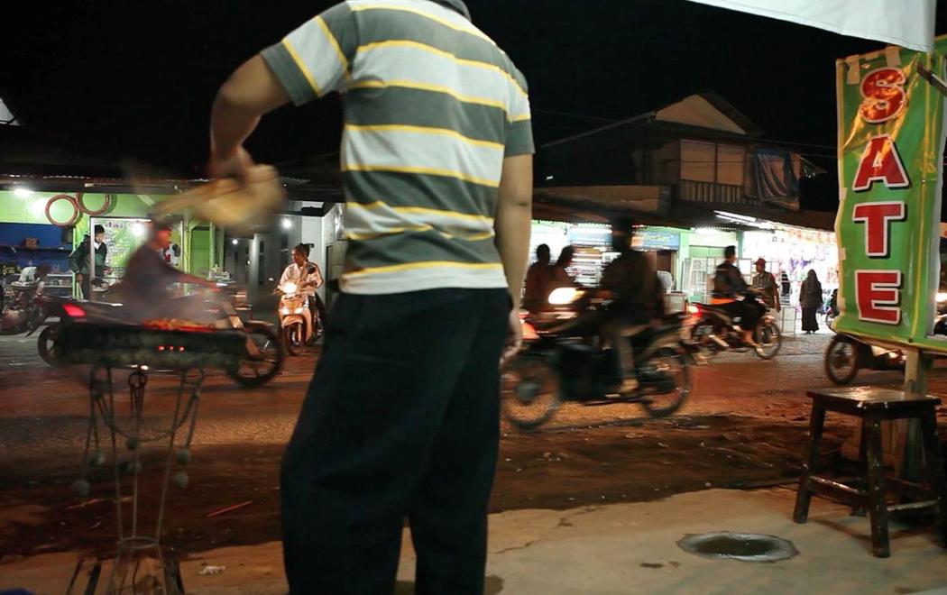 Someone is cooking food near a busy street