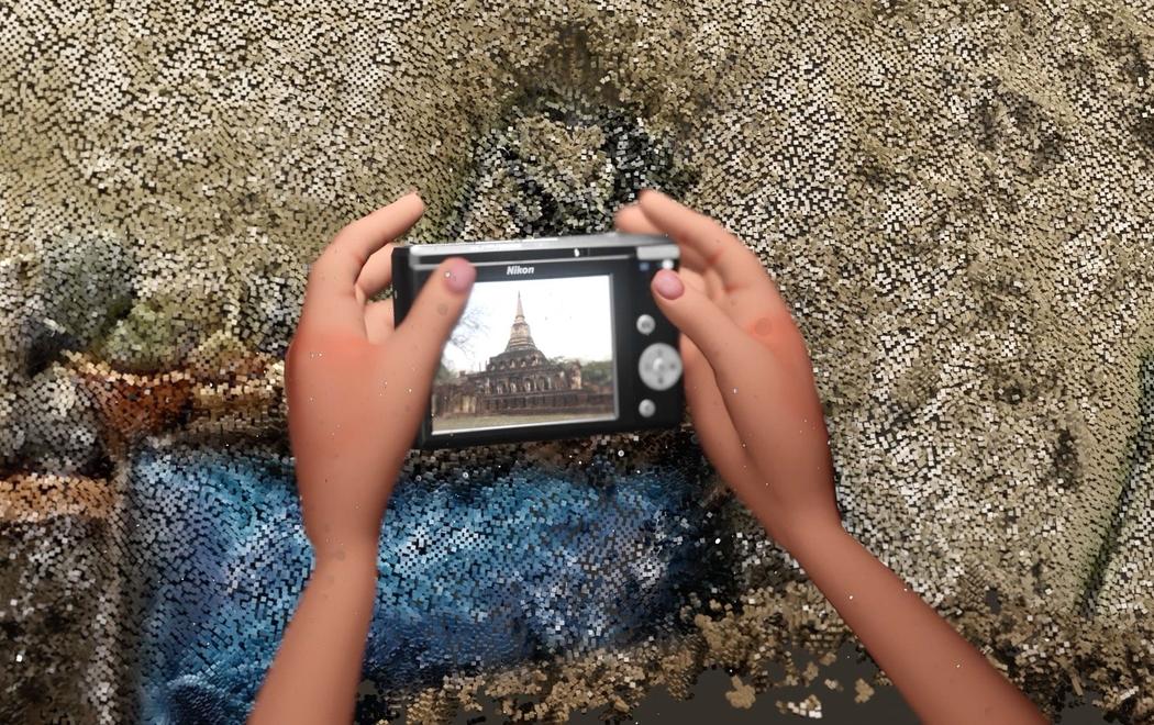 A pair of animated hands holds a camera in front of a pixellated background. On the viewfinder of the camera we see a Thai temple