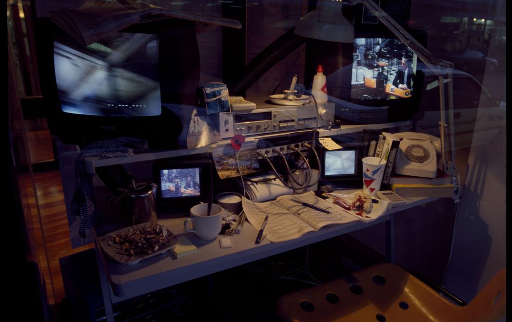 A desk with multiple screens showing surveillance footage