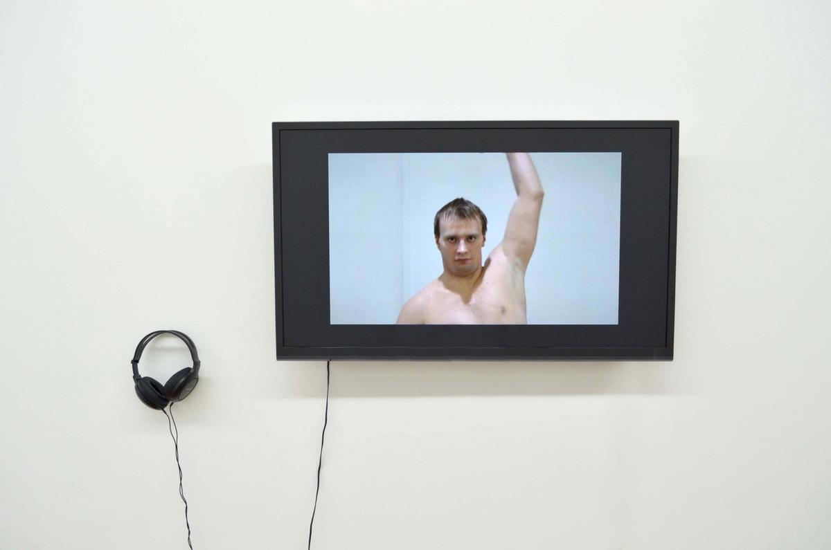 A tv with headphones shows a man lifting his arm up