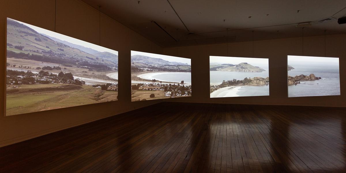 A four channel video installation in a darkened gallery showing a landscape