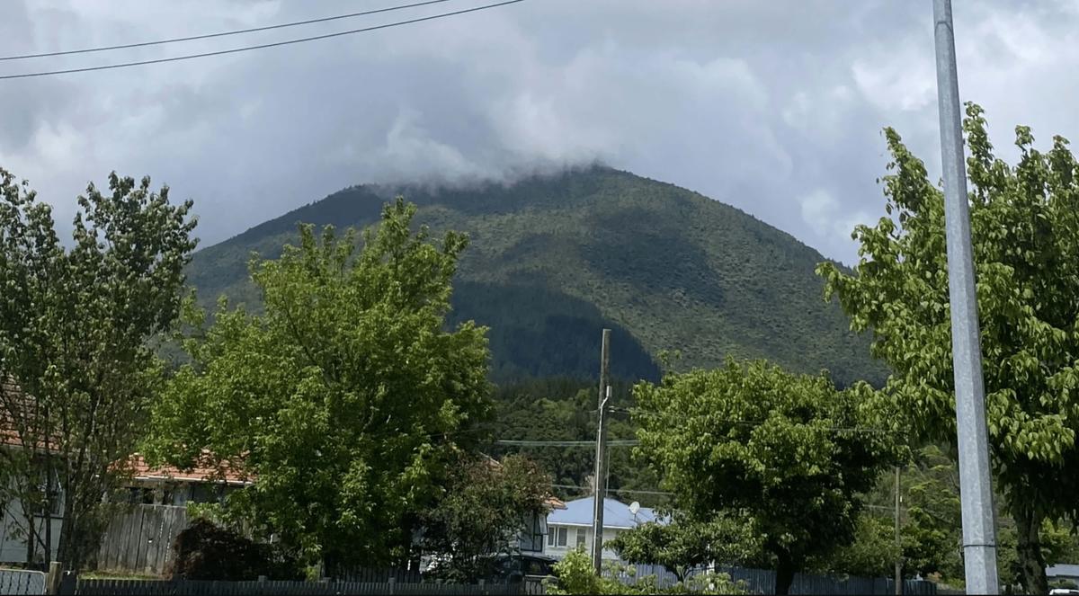 View of a suburban neighbourhood with a large misty hill in the background