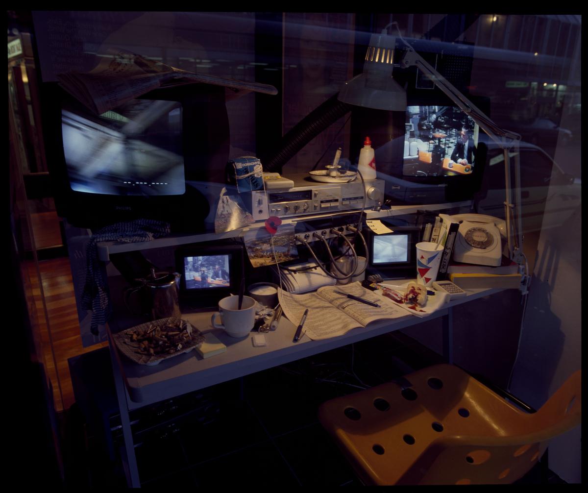 A desk with multiple screens showing surveillance footage