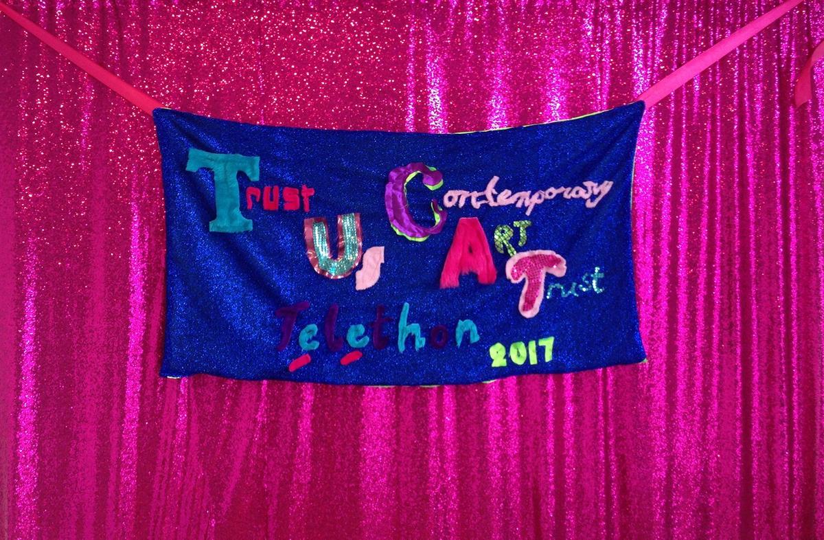 A handmade fabric sign reading "Trust Ss Contemporary Art Trust Telethon 2017"