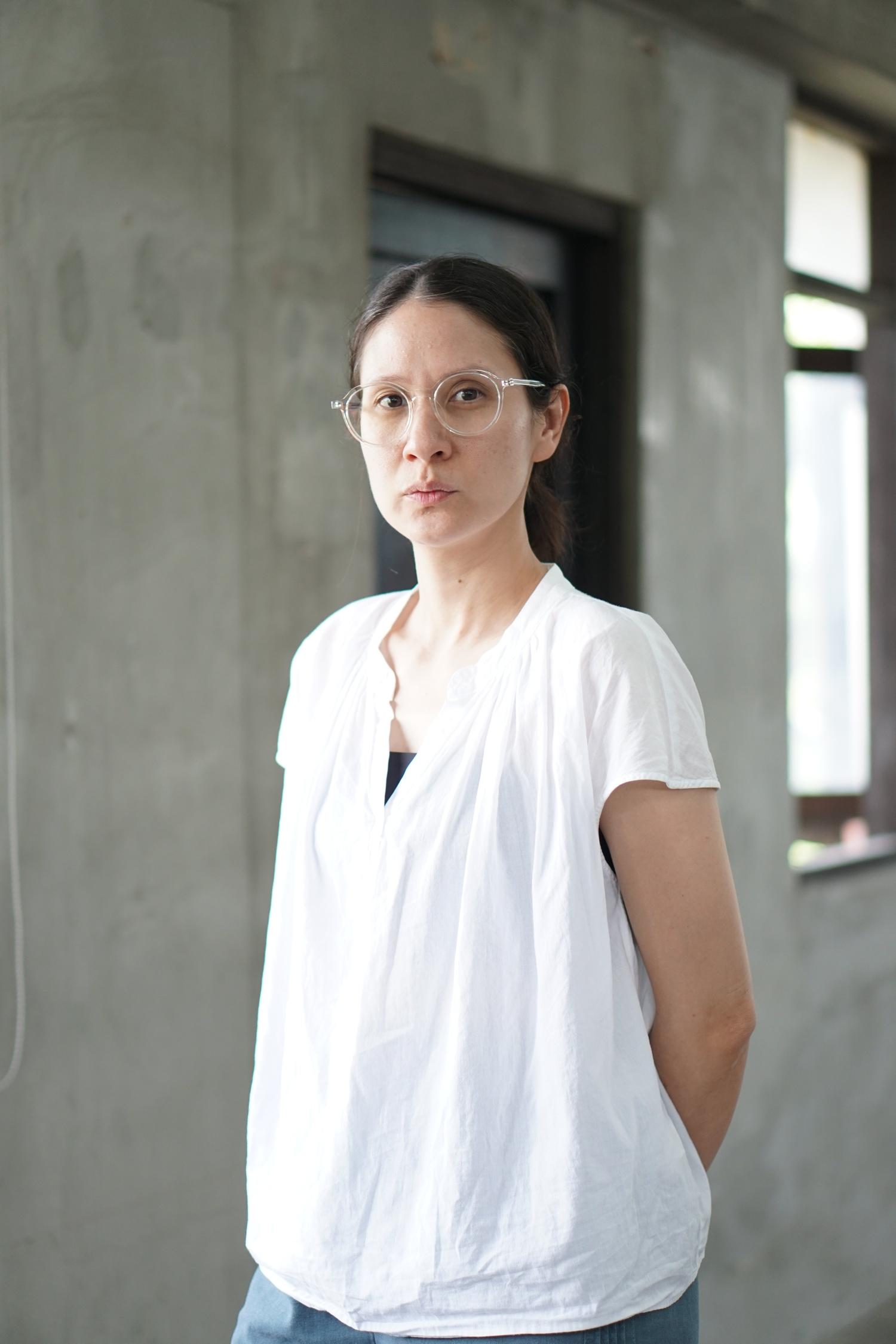A woman in a white shirt and glasses