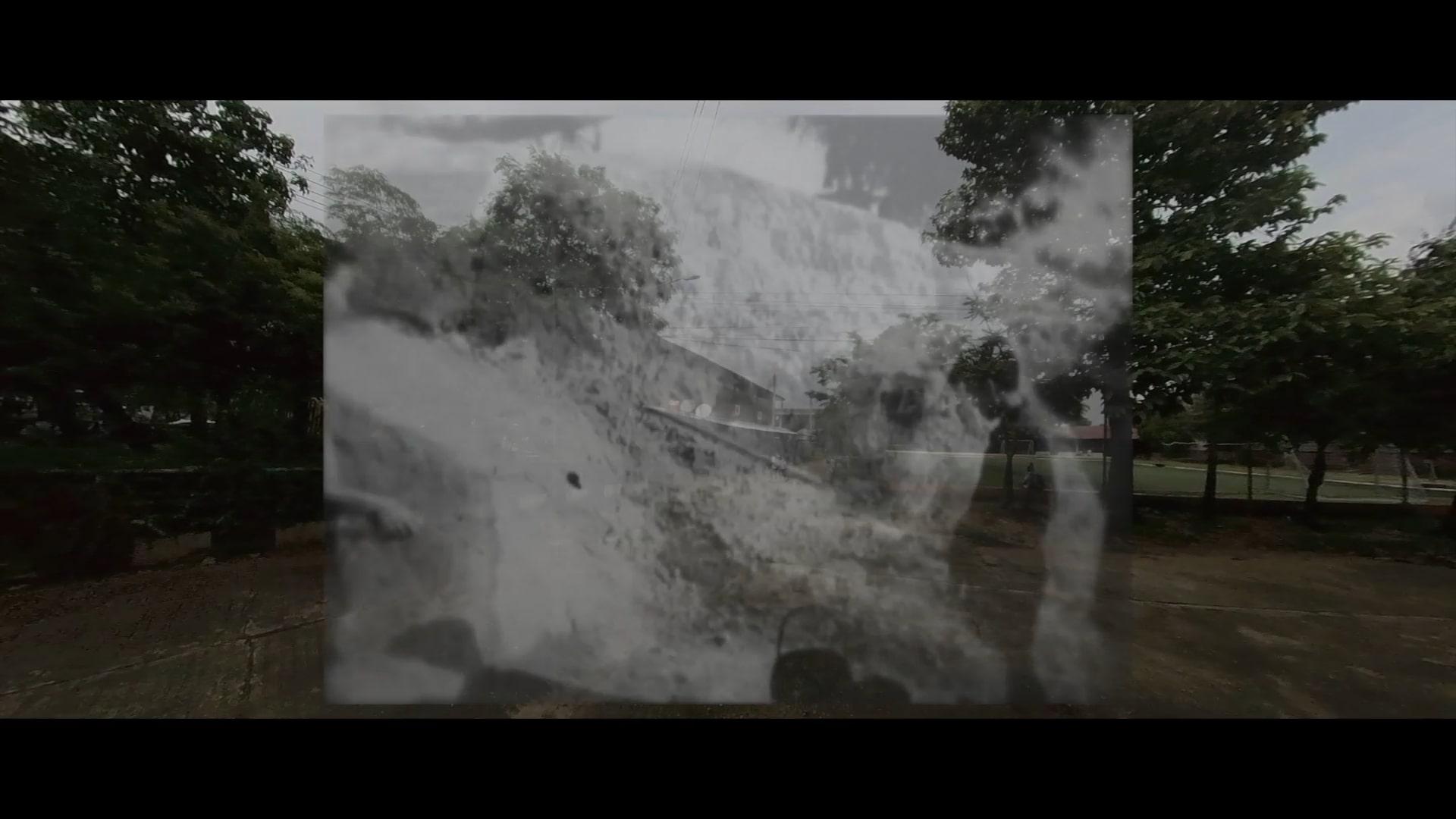 An old black and white film showing a boy in a quarry is superimposed over a modern day rural scene