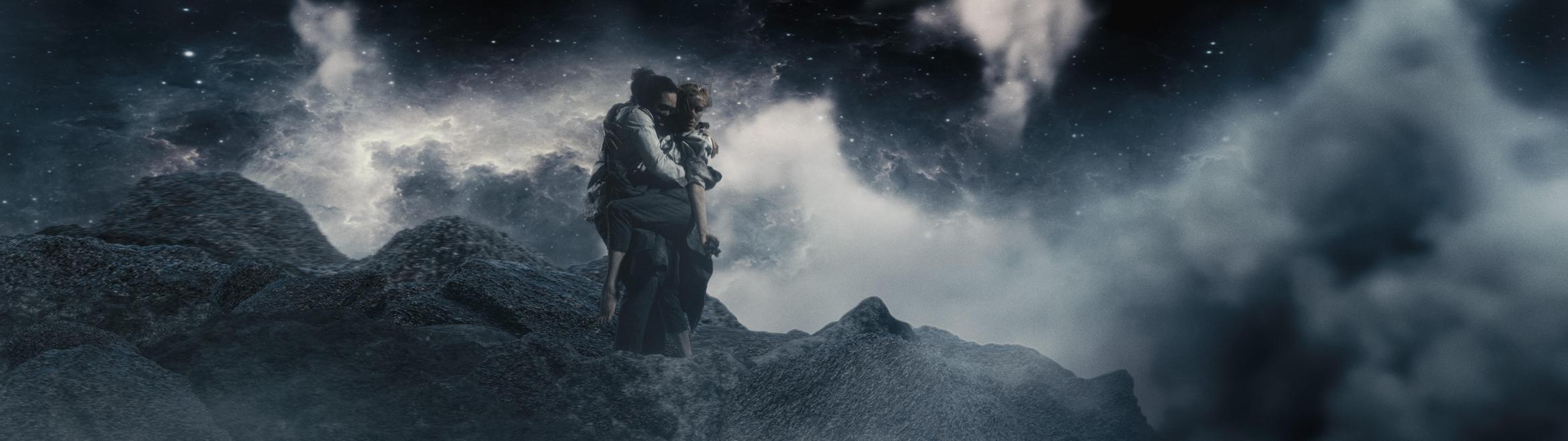 A man carries a woman across a rocky, otherworldy landscape, surrounded by a dramatic night starscape..