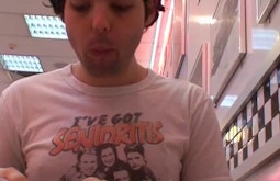 A person sits in a diner filming himself eating.