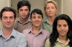 5 people wearing similar shirts stare down the camera.
