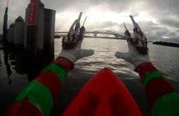 A POV showing Freddy Kruger-esque hands reaching out while in a kayak in a large harbour.