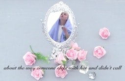 A person resembling a religious figure is seen in the reflection of an ornate mirror. Around the mirror are pink roses.