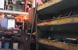 A busy car garage with scrap metal lying on all surfaces.