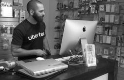 A man behind a counter in a device repair shop.