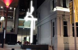 A digitally rendered abstract sculpture lights up outside an art gallery.