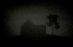 A silhouetted house and tree against a dark sky.