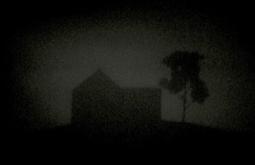 A silhouetted house and tree against a dark sky.