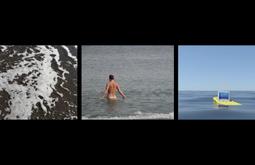 Three films side by side. The first of a shallow wave. The second of a person wading naked into the water. The third of a digital sea with a computer floating in the water.