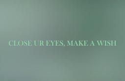 A blurry screen of leaf green has the text 'Close ur eyes, make a wish' written overtop.