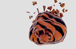 A digitally rendered tiger's head floats over a white background. The head is shattering into small pieces.