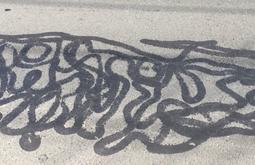 A squiggly black line is drawn on concrete.