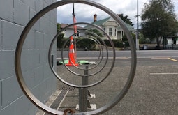 Circular bike stands are lined up to create a tunnel view.