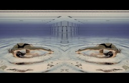 A mirrored image of a person swimming in a pool as seen from underwater.