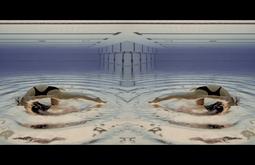 A mirrored image of a person swimming in a pool as seen from underwater.
